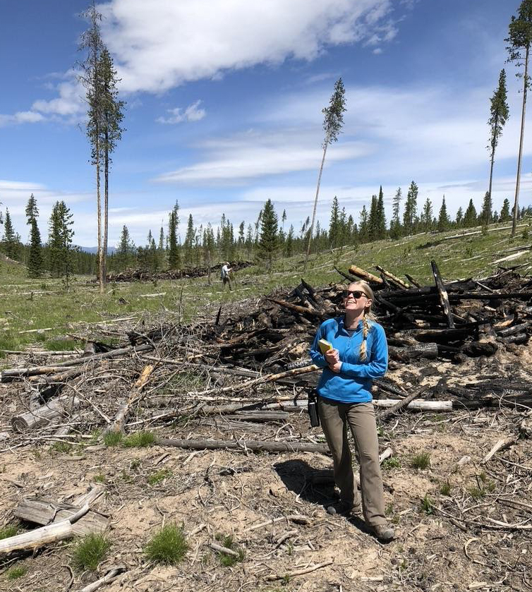 Amelia Nelson by a pile burn scar near Bozeman, MT